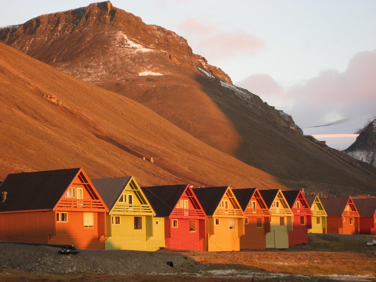 Rij gekleurde huisjes in Longyearbyen onder de middernachtszon | IJsland Tours