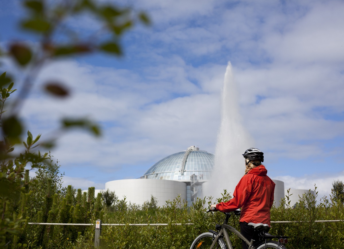 Fietser in Reykjavik bij de Perlan met fontein | Arctic Adventures | IJsland Tours