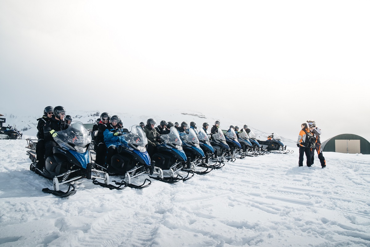 Een rij sneeuwscooters klaar voor de start | Mountaineers of Iceland | IJsland Tours