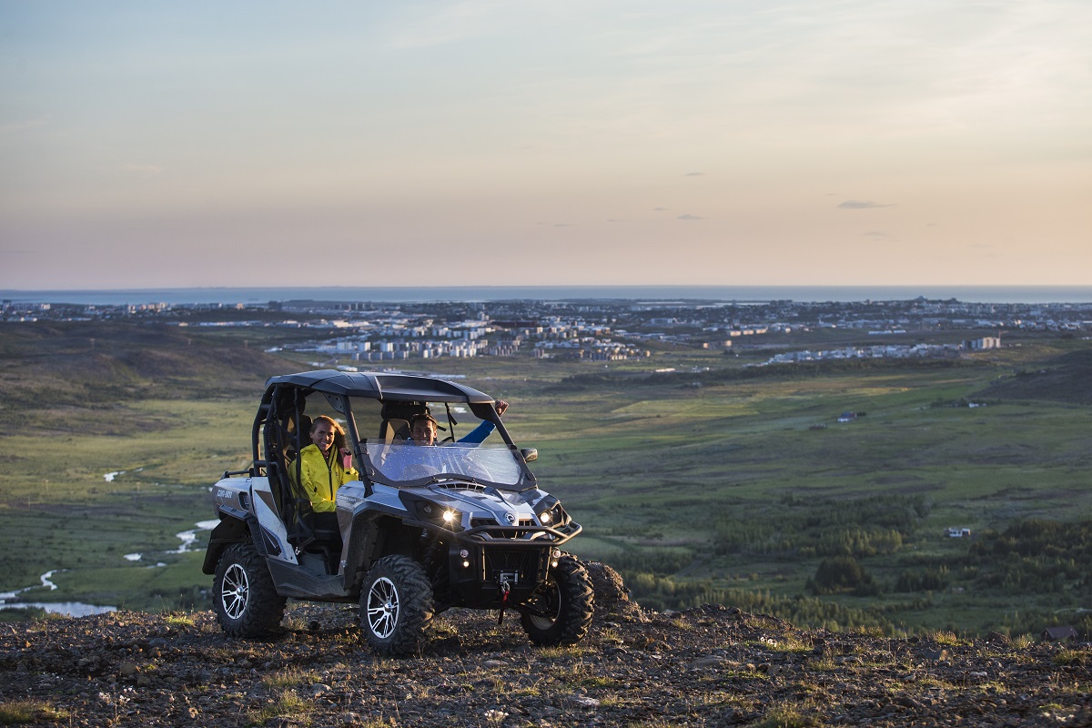 Vrolijke reizigers in een buggy met uitzicht over een stad | Erlendur Thor Magnusson | Safari Quads | IJsland Tours